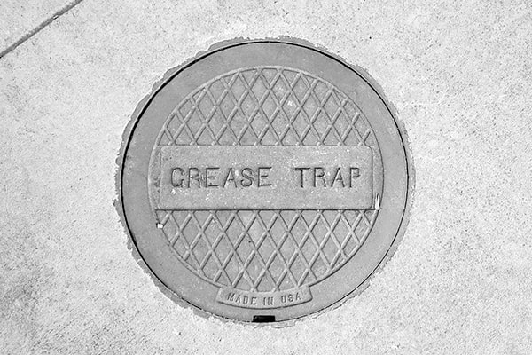 many local ordinances require regular grease trap pumping to prevent sewer system blockages